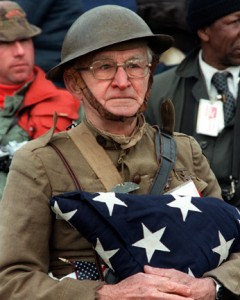 Joseph Ambrose, an 86-year-old World War I veteran, attends the dedication day parade for the Vietnam Veterans Memorial.  He is holding the flag that covered the casket of his son, who was killed in the Korean War. Photo originally from en.wikipedia. 